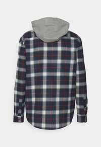 Marineblaues, weißes und rotes kariertes Langarmhemd mit geknöpften Manschetten und angebrachtem hellgrauem Stoffkapuze, von hinten gezeigt.