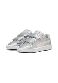 Baskets argentées scintillantes avec des bandes Velcro et un logo PUMA rose. Texture lisse, bout arrondi et semelle en caoutchouc blanche.