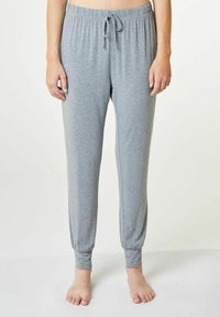 Grå, lätta joggers med elastisk midja, dragsko och åtsittande muddar vid anklarna, som visar en slät, mjuk textur.