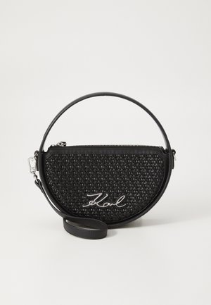 Black circular handbag with woven texture, silver hardware, and a signature logo. Features a detachable strap and zippered compartment.