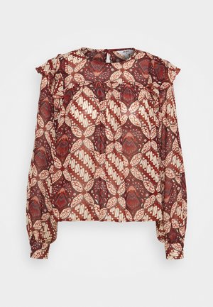 Long-sleeve blouse with brown and cream geometric floral pattern, ruffled yoke, buttoned cuffs, and back keyhole closure.