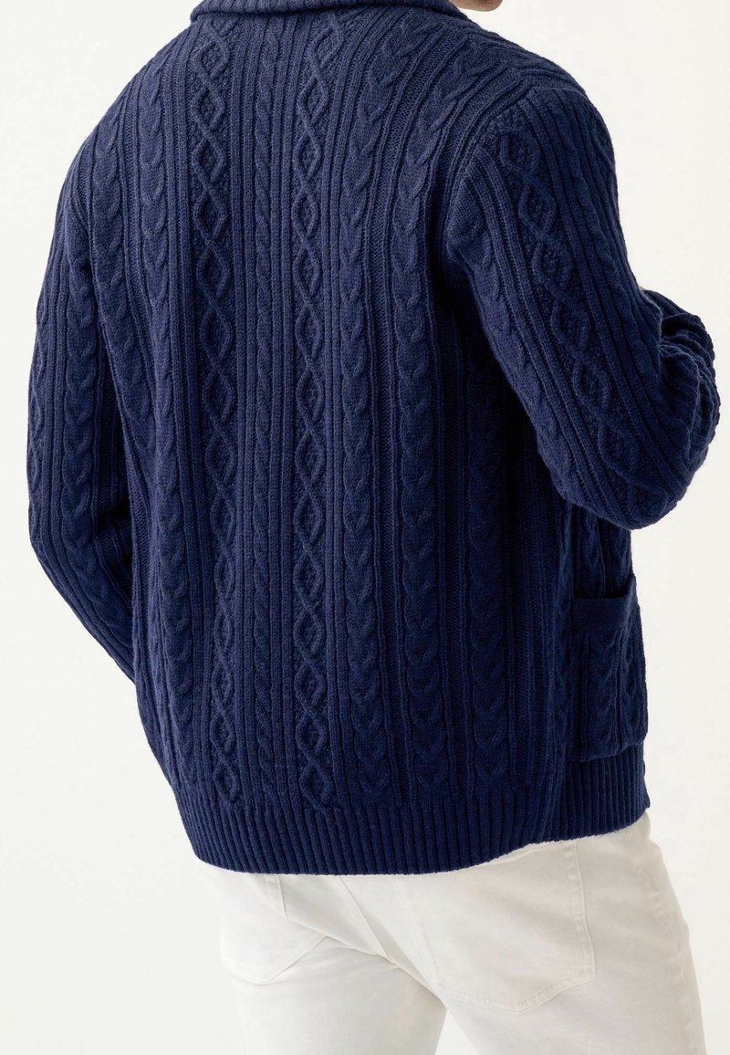 Cardigan lavorato a maglia blu navy con motivo a corda, orlo a costine e tasche laterali. Progettato con colletto a scialle e finitura testurizzata.