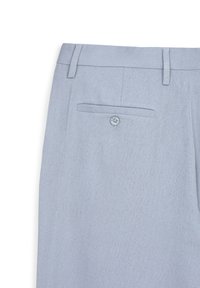 Pantaloni leggeri blu con passanti per cintura e una tasca posteriore con bavetta fissata da un bottone su uno sfondo bianco.