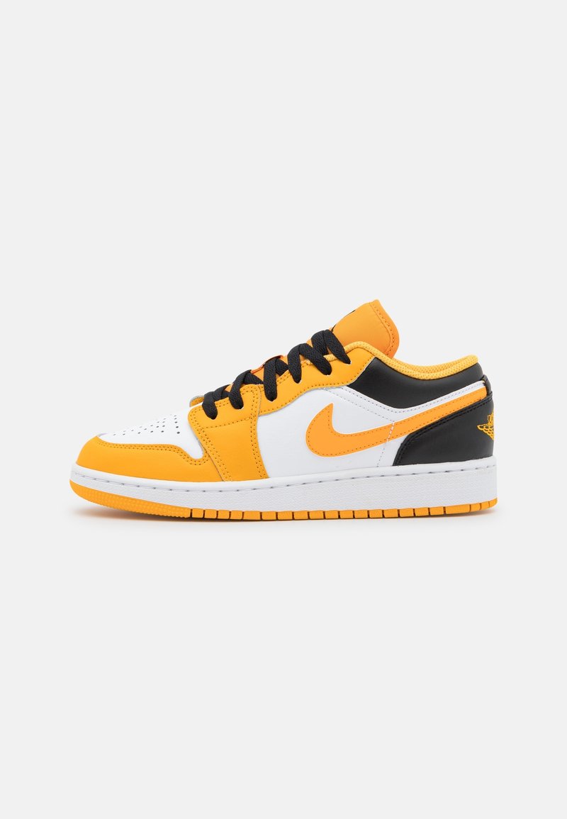 Nike Air Jordan 1 Low-sneakers har en design i gult, svart och vitt läder, med svarta snören och en texturerad gummisula.