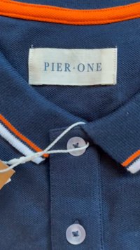 Námořnická polo košile s obojkem v oranžových a bílých pruzích, plastovými knoflíky a štítkem s nápisem "PIER • ONE." Texturovaná tkanina se zaraněným detailem.