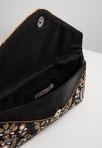 Černé látkové psaníčko s ozdobnými korálkovými aplikacemi. Disponuje zapínáním na druk, vnitřní kapsou a hladkou saténovou podšívkou.