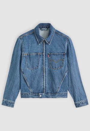 Denimjakke i lyseblå, med krave, to brystlommer og syninger. Har en frontlynlås og knaplukning.