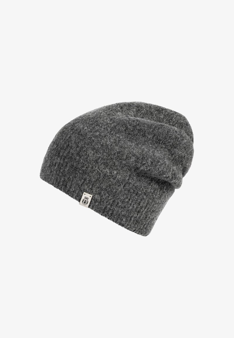 Dark gray knitted beanie with a small rectangular fabric tag on the edge, textured wool material, slouchy fit design.