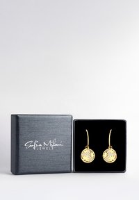 Guldörhängen med cirkulära hängen som har intrikata blommönster, placerade i en svart texturerad presentlåda med ett sammetfoder.