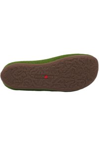 Grön filt innersula med en texturerad brun gummibotten. "Haflinger"-logotypen synlig i rött på innersulan, som visar intrikata mönster.