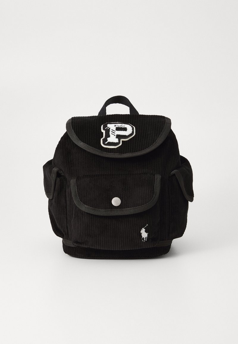 Mochila de veludo cotelê preta com aba dobrável, fecho de pressão prateado, bolsos frontais e detalhes de logotipo bordados. Possui alças de ombro resistentes.