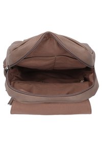 Mochila de piel marrón con cierre de cremallera. El interior espacioso cuenta con un forro de tela suave y un pequeño bolsillo interior.