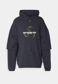 Felpa over-size blu navy con dettagli strappati, caratterizzata da un logo grafico in verde e rosso. Realizzata in tessuto morbido con cappuccio regolabile con cordino.