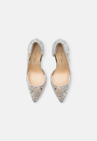 Ballerine argento a punta con intricate decorazioni in pizzo floreale e una fodera interna liscia. I lati aperti migliorano la traspirabilità e lo stile.