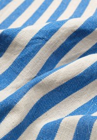 Striped fabric featuring alternating blue and natural color stripes, made of woven textile with a textured finish.