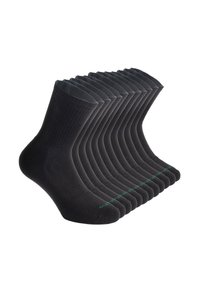 Calcetines de algodón negros dispuestos en fila, con textura acanalada, punta reforzada y un acento verde en las suelas.