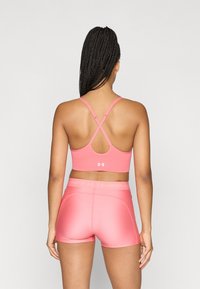 Ροζ αθλητικό σουτιέν με χιαστί τιράντες στην πλάτη και ταιριαστό σορτς. Λείο ύφασμα με λογότυπο στη ζώνη της πλάτης. Εφαρμοστή σχεδίαση.