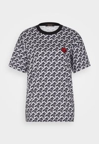 T-shirt z krótkim rękawem w czarno-białym geometrycznym wzorze, z czarnym kołnierzykiem i małym czerwonym logo na górnej lewej stronie klatki piersiowej.