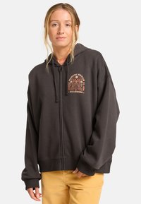 Czarny szary hoodie na zamek błyskawiczny o luźnym kroju, z grafiką z przodu w kolorze pomarańczowym, ściągaczami u nadgarstków i miękką, teksturowaną tkaniną.