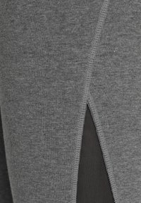 Gray athletic leggings featuring a textured fabric with a mesh panel inset at the side, reinforced stitching along the seams.