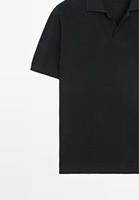 Polo noir à manches courtes avec un motif tricoté texturé, col et décolleté en V ouvert sur fond blanc.