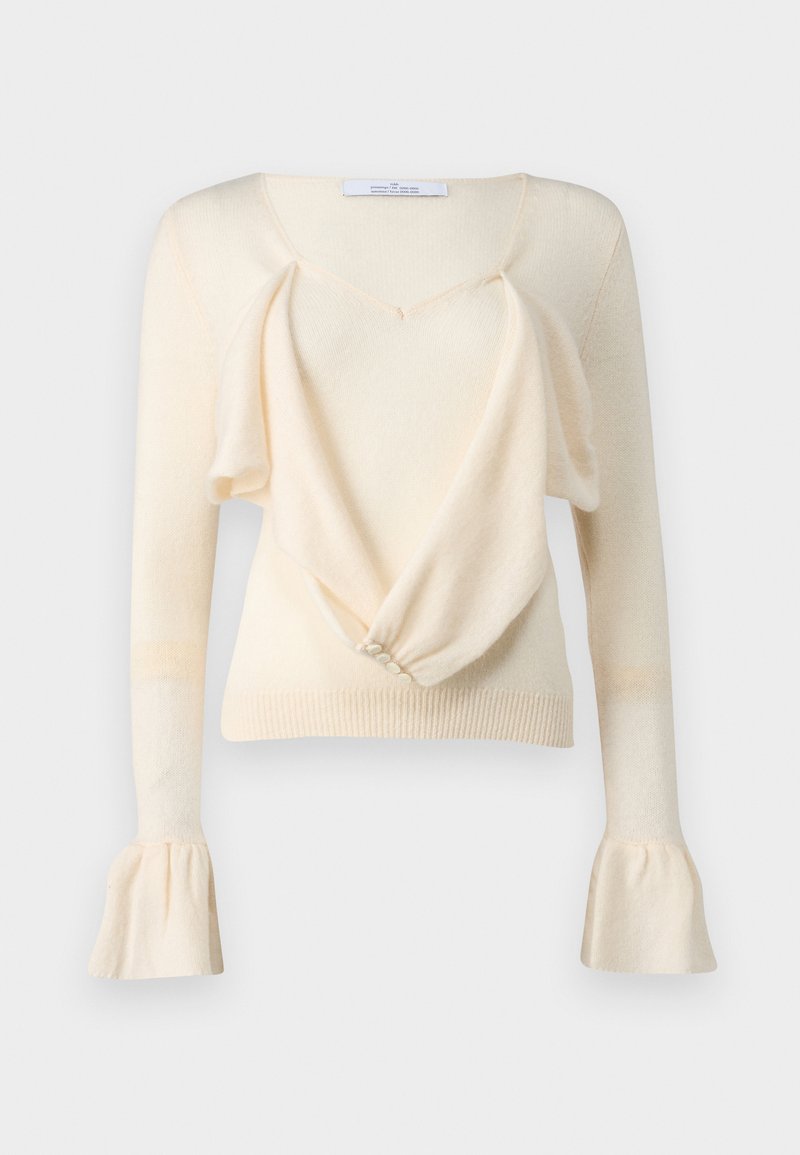 Pull crème avec un décolleté en V profond, un devant drapé et des manches longues avec des poignets évasés. Texture douce et détail de bouton à l'avant.