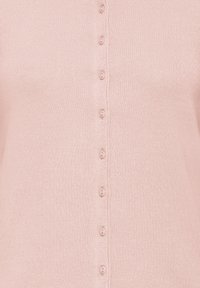 Világos rózsaszín kötött anyag függőleges sorban kis, hozzáillő rózsaszín gombokkal a középen.