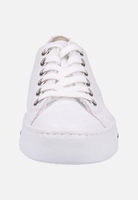 White canvas sneaker with a rounded toe, silver eyelets, and white laces. The sole is textured rubber, creating a lightweight design.