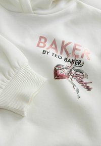 Biała bluza z kapturem z prążkowanymi mankietami, z metalicznym różowym napisem "BAKER BY TED BAKER" oraz nadrukiem różowej torebki z szarym wstążką.