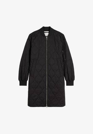 Czarny pikowany długi płaszcz z zamkiem błyskawicznym z przodu, prążkowanymi mankietami i boczną kieszenią na zamek. Posiada zaokrąglony kołnierz i gładką fakturę.