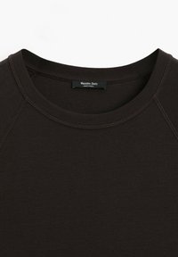 Gros plan sur l'encolure et les épaules d'un t-shirt noir uni à col rond avec une étiquette "Massimo Dutti" à l'intérieur du col.