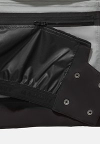 Schwarzes und graues Innenfutter der Tasche mit einer Reißverschlusstasche und einem strukturierten, flexiblen schwarzen Stoff. Verfügt über auffällige silberne Beschläge und Logodetails.