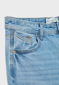 Světle modré džíny z denimu s jemným efektivním opráním. Mezi funkce patří zlaté kovové prvky, přední kapsy a viditelná etiketa na pásku.