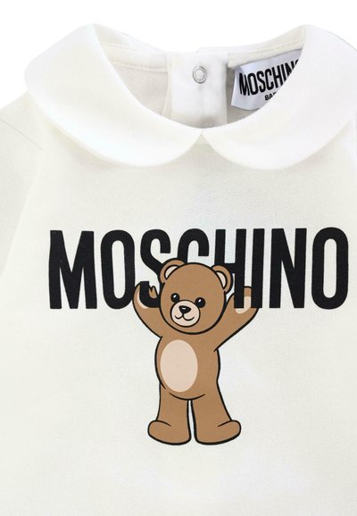 Weißes Baumwollkleidungsstück mit rundem Kragen, das ein auffälliges braunes Bären-Motiv und den fetten "MOSCHINO"-Schriftzug darunter zeigt.