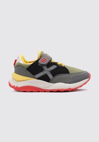 Zapatilla que presenta una combinación de materiales grises, amarillos y negros, con una distintiva suela roja y una correa de Velcro, diseñada para la comodidad y la estabilidad.