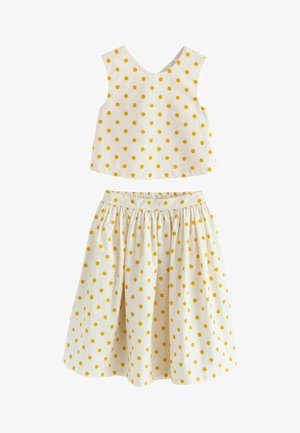 Witte mouwloze cropped top en geplooide rok met gele polkadots, ontworpen voor meisjes.
