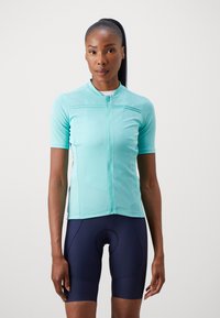 Kurze Fahrradtrikot in Hellblau mit einem Frontreißverschluss und strukturiertem Stoff, kombiniert mit dunkblauen Fahrradhosen mit gepolsterter Sitzfläche.