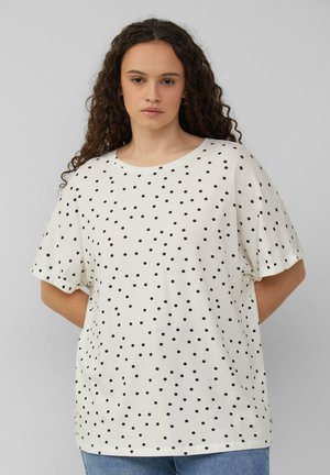 Kremowa koszulka z krótkim rękawem w czarne kropki. Luźny krój, okrągły dekolt, miękki materiał bawełniany. Casualowy design, prosty styl.