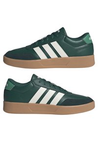 Sneakers verdi in pelle con strisce bianche, suola in gomma color naturale, colletto imbottito e puntale testurizzato. Design elegante e dal profilo basso, ideale per un look casual.