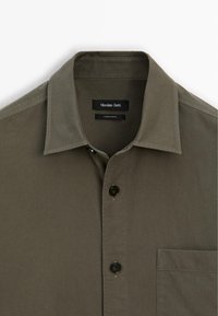 Olijfgroene button-up shirt van katoen, met een klassieke kraag, borstzak en donkere knopen. Label leest "Massimo Dutti."