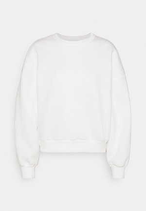 Sweatshirt blanc avec un col rond, coupe ample et manches longues, doté de poignets et d'un ourlet côtelés. Texture douce et lisse sans motifs.