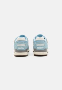 Svijetloplave suede tenisice s mrežastim detaljima, bijelim jastučićem na peti i sivoj potplati. Sadrže natpis "SAUCONY" na tabanici pete.
