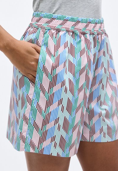 Εκτυπωμένο σορτς με πολύχρωμο ζιγκ ζαγκ μοτίβο σε κόκκινο, μπλε, πράσινο και ροζ. Ελαστική μέση με πλαϊνές τσέπες.