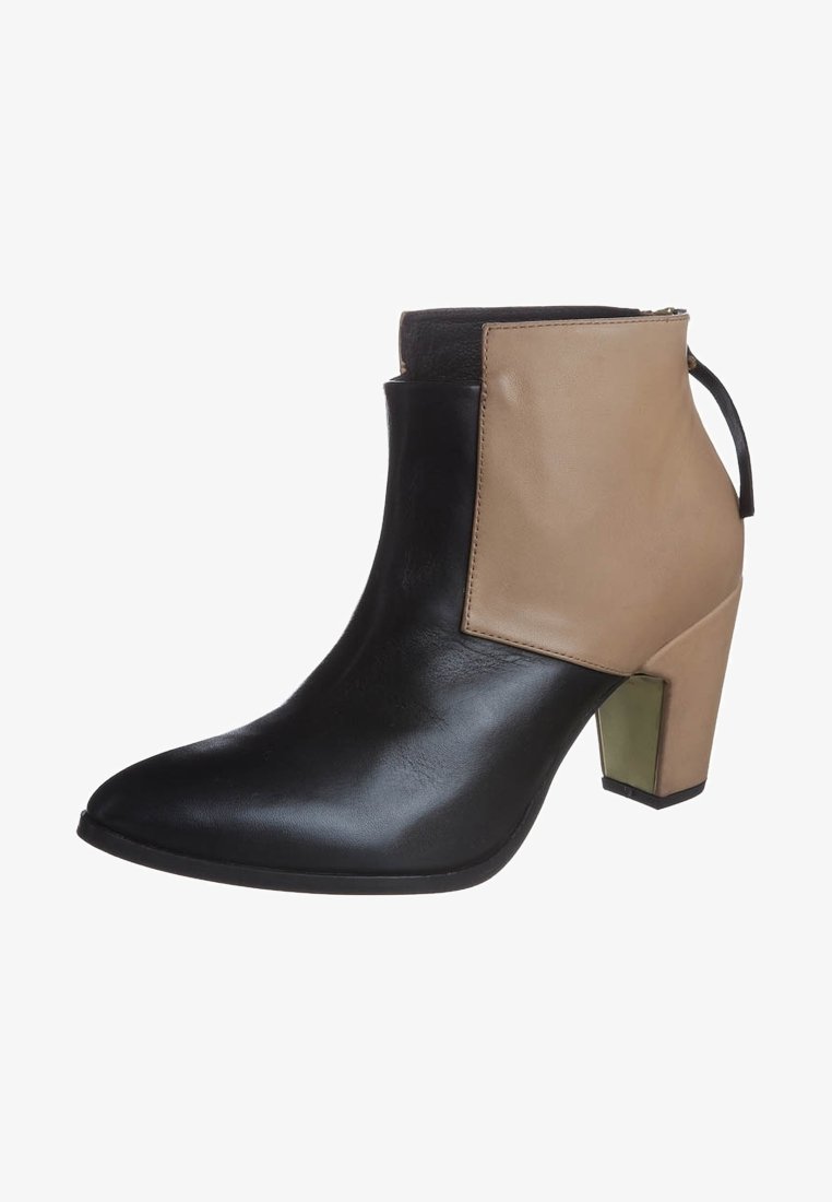 Bottine à bout pointu, devant noir et arrière beige, talon bloc avec détail métallique et fermeture éclair au dos.