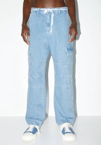 Pantalones cargo azul claro con cintura ajustable, que cuentan con múltiples bolsillos y un corte relajado. Fabricados en denim con una superficie texturizada.