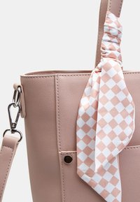 Roze faux leren tote bag met een gestructureerd ontwerp. Kenmerkt een geruite sjaalaccent in wit en perzik, en een zilveren sluiting.