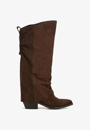 Botte hauteur genou en daim marron avec un talon bloc bas, un bout arrondi et un détail froncé avec des boutons sur le côté arrière supérieur.