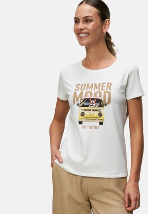 T-shirt blanche à manches courtes avec un graphisme d'un van jaune et d'un corgi, texte imprimé "L'HUMEUR D'ÉTÉ EN CHEMIN" en doré.