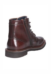 Bruine leren enkellaarzen met een gladde textuur, voorzien van een zijrits, veters en brogue-details langs de bovenkant en zool.