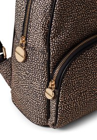 Muster-Rucksack in Schwarz und Beige aus strukturiertem Stoff, mit goldfarbener Hardware und zwei Reißverschlussfächern.